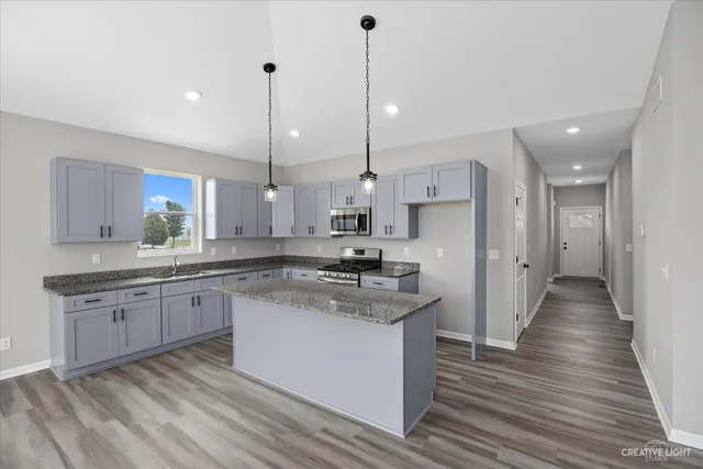 a kitchen with stainless steel appliances granite countertop a sink stove and refrigerator