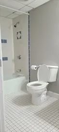 a white toilet sitting next to a bathroom sink and tub