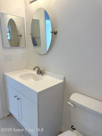 a bathroom with a sink mirror and toilet