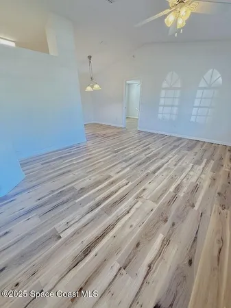 a view of a room with wooden floor and ceiling fan