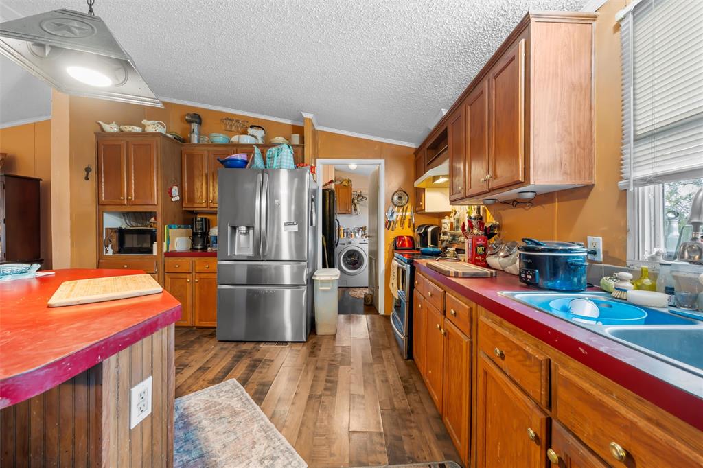 236 Bode Road Elm Mott, TX 76640 - Photo 14 of 33 a kitchen with stainless steel appliances granite countertop a refrigerator a oven and a sink with wooden cabinets