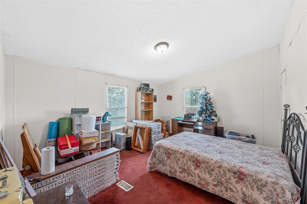 236 Bode Road Elm Mott, TX 76640 - Photo 15 of 33 a bedroom with a bed a table and a bookshelf