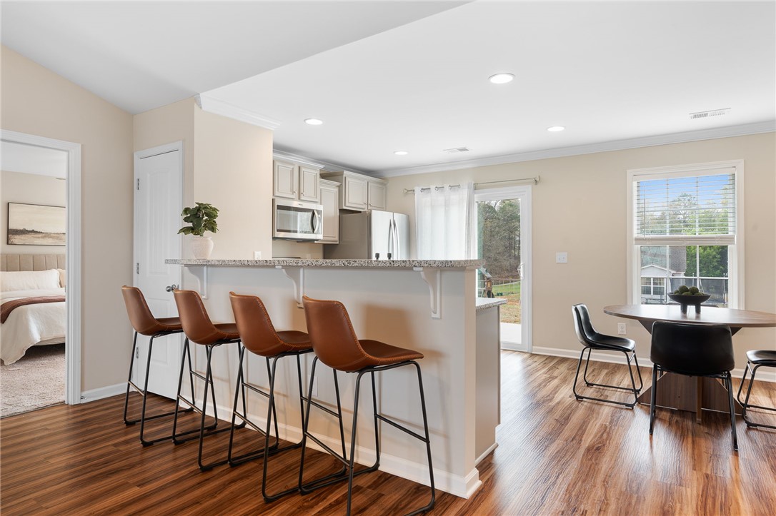 114 Sunny Pt Loop Central, SC 29630 - Photo 9 of 25 This bright and airy kitchen with a convenient breakfast bar flows seamlessly into the dining area.