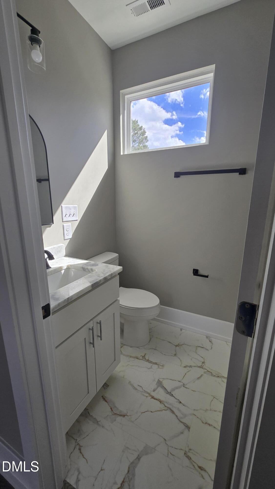 1013 Carroll Street, Unit B Durham, NC 27707 - Photo 2 of 4 a bathroom with a granite countertop toilet and a sink