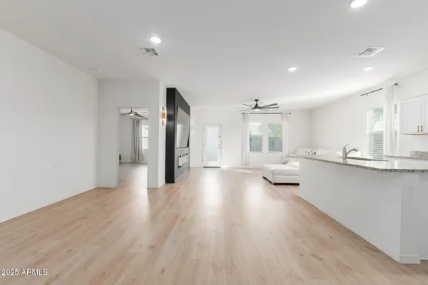 a large living room with stainless steel appliances lots of counter space and wooden floor
