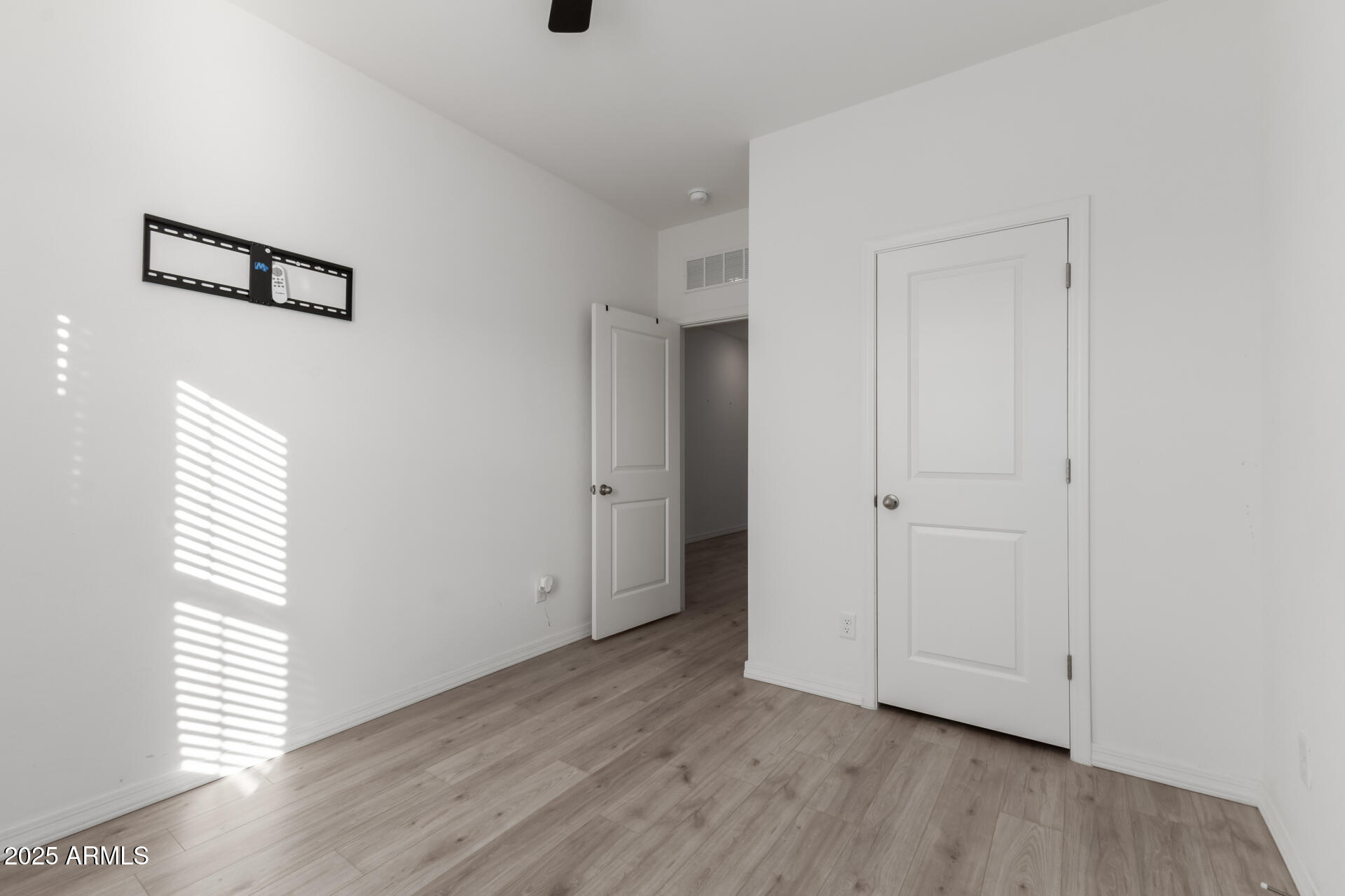 8133 South 64th Lane Laveen, AZ 85339 - Photo 21 of 32 a view of an empty room with wooden floor and a window