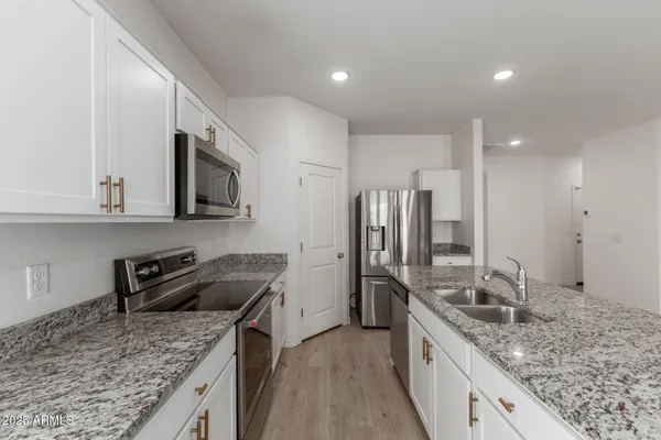 a kitchen with stainless steel appliances granite countertop a sink stove and refrigerator