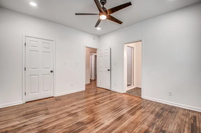 a view of empty room with wooden floor