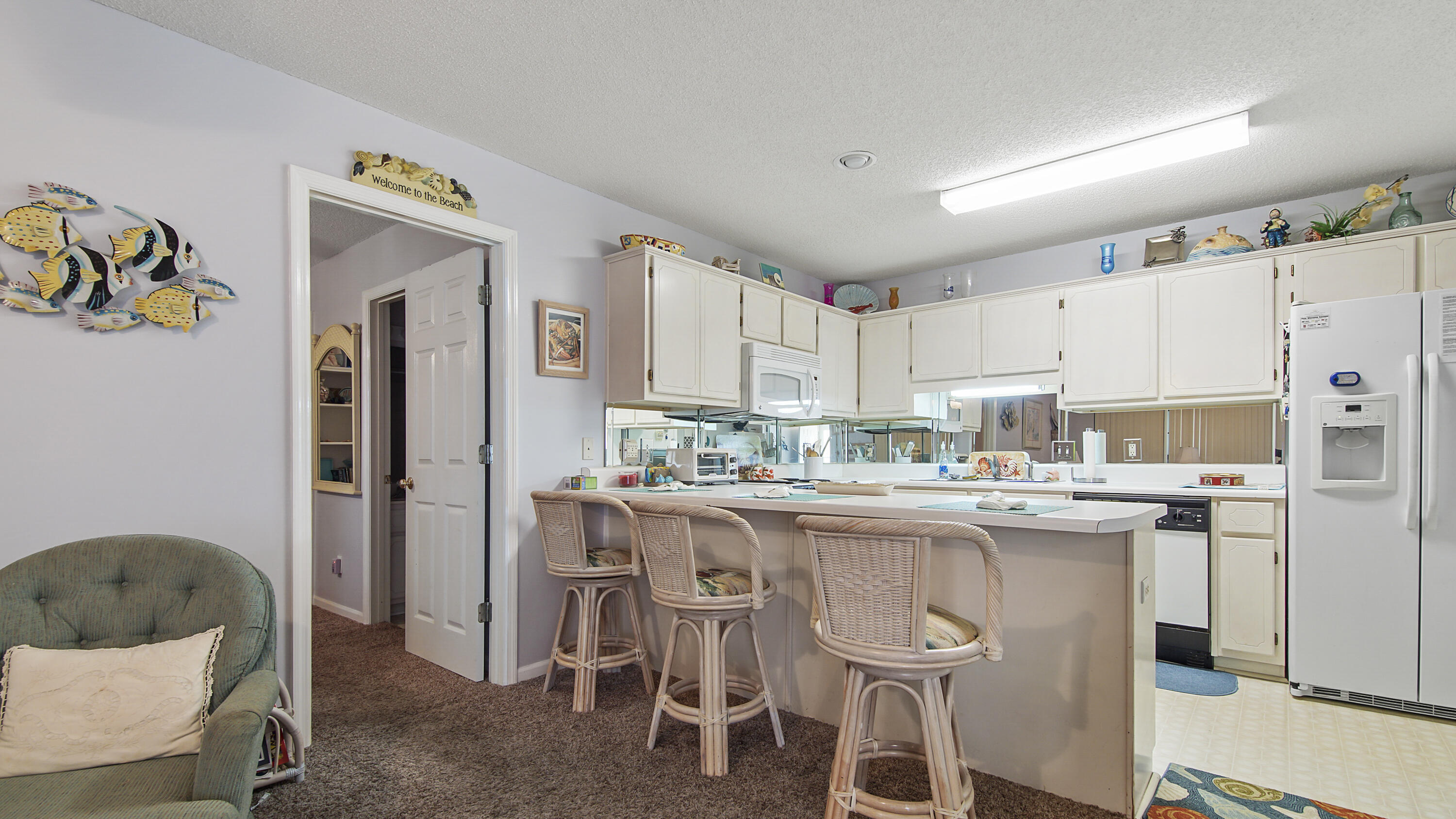 17462 Front Beach Road, Unit 54106 Panama City Beach, FL 32413 - Photo 19 of 32 a kitchen with a sink a refrigerator and wooden cabinets