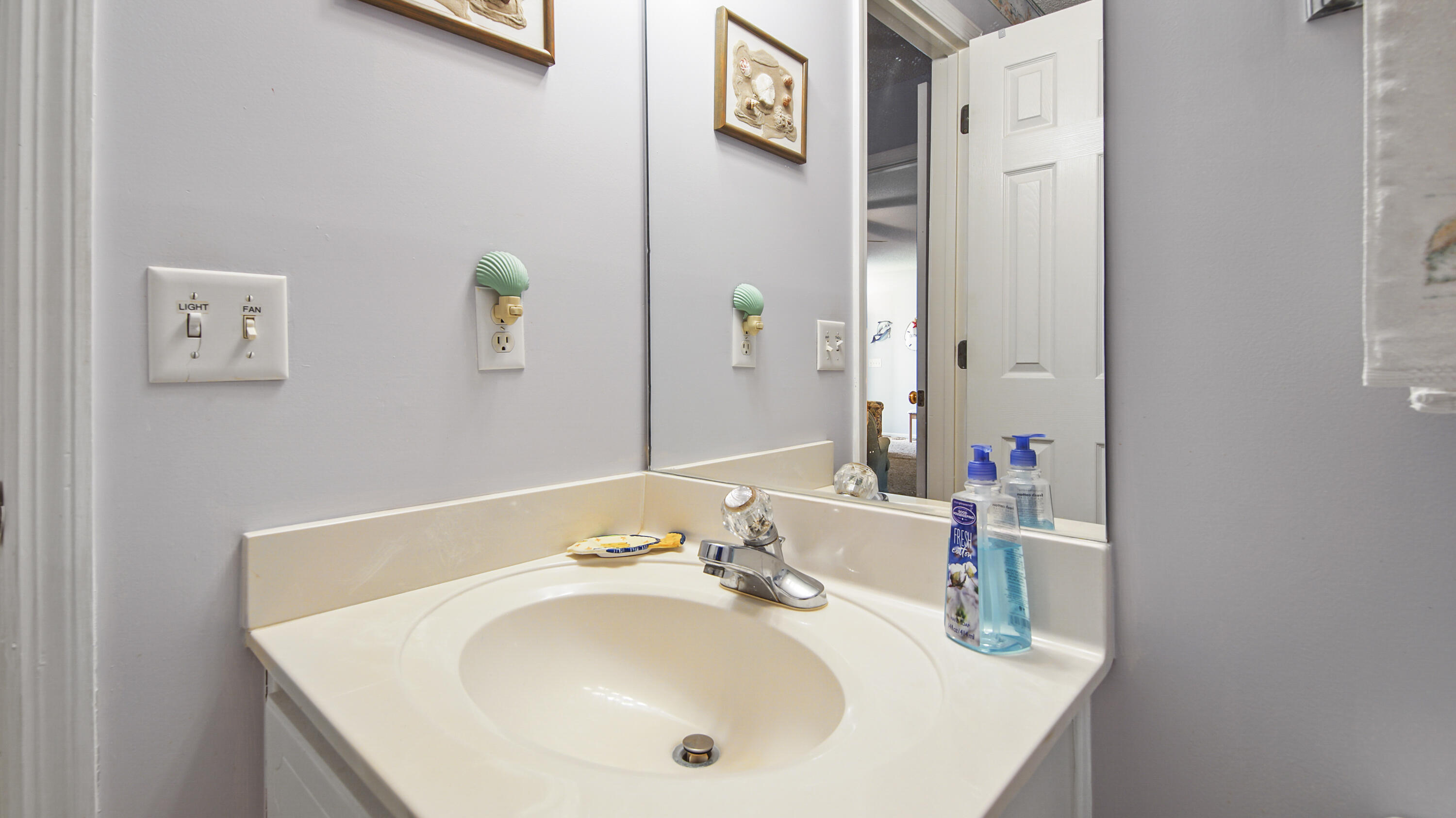 17462 Front Beach Road, Unit 54106 Panama City Beach, FL 32413 - Photo 31 of 32 a bathroom with a sink and a mirror