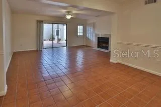 a view of an empty room with window and fireplace