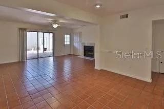 an empty room with windows and fireplace