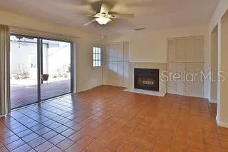a view of an empty room with a fireplace and a window