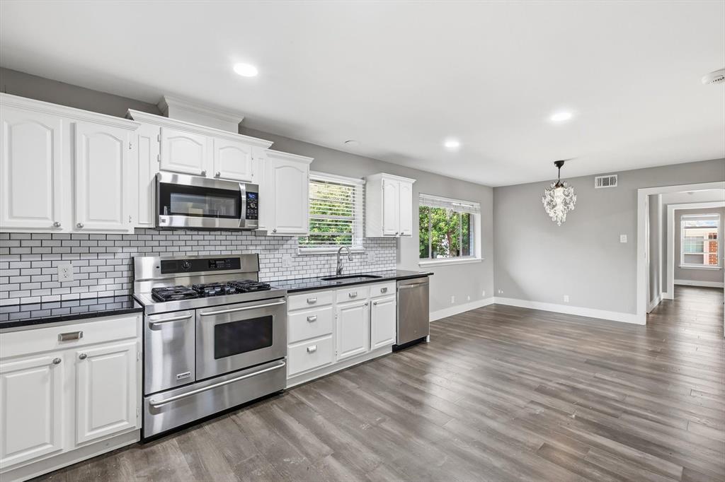 6611 Highgate Lane Dallas, TX 75214 - Photo 19 of 39 Kitchen featuring stainless steel appliances, white cabinetry, hanging light fixtures, dark wood finished floors, and recessed lighting