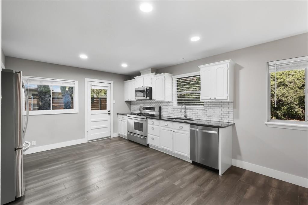 6611 Highgate Lane Dallas, TX 75214 - Photo 21 of 39 Kitchen featuring appliances with stainless steel finishes, white cabinets, decorative backsplash, dark wood-type flooring, and recessed lighting