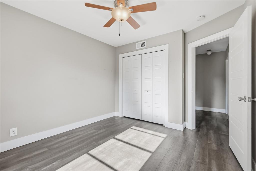 6611 Highgate Lane Dallas, TX 75214 - Photo 27 of 39 Unfurnished bedroom with dark wood-style floors, ceiling fan, and a closet