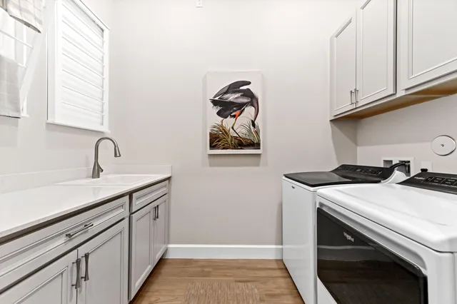 a hallway with cabinets a sink and a window