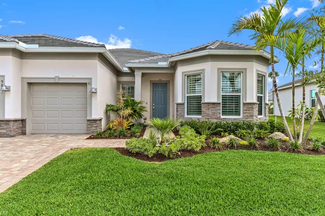 a front view of a house with a garden and plants