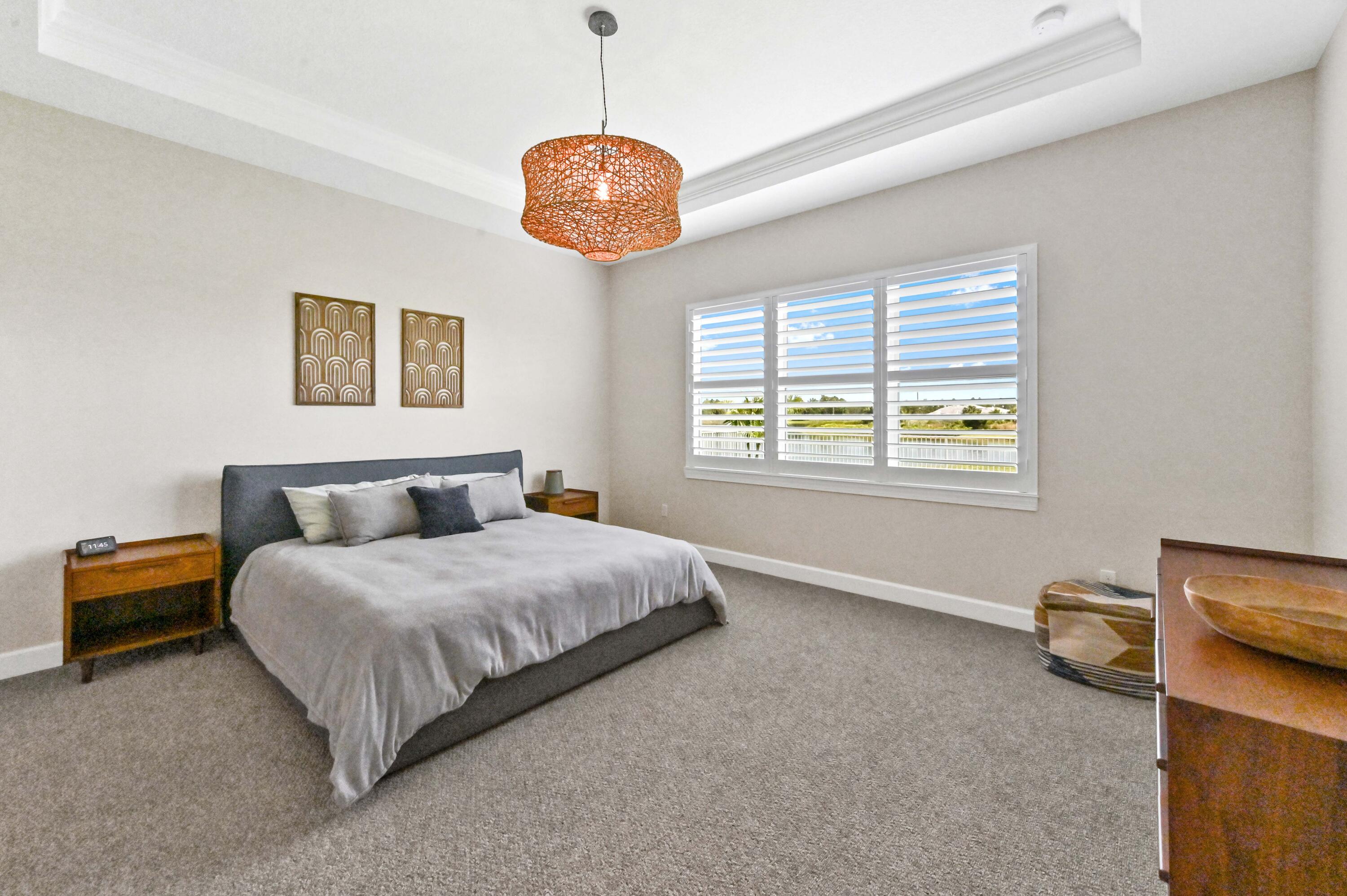 9891 Southwest Legacy Drive Stuart, FL 34997 - Photo 21 of 55 a spacious bedroom with a bed and a window