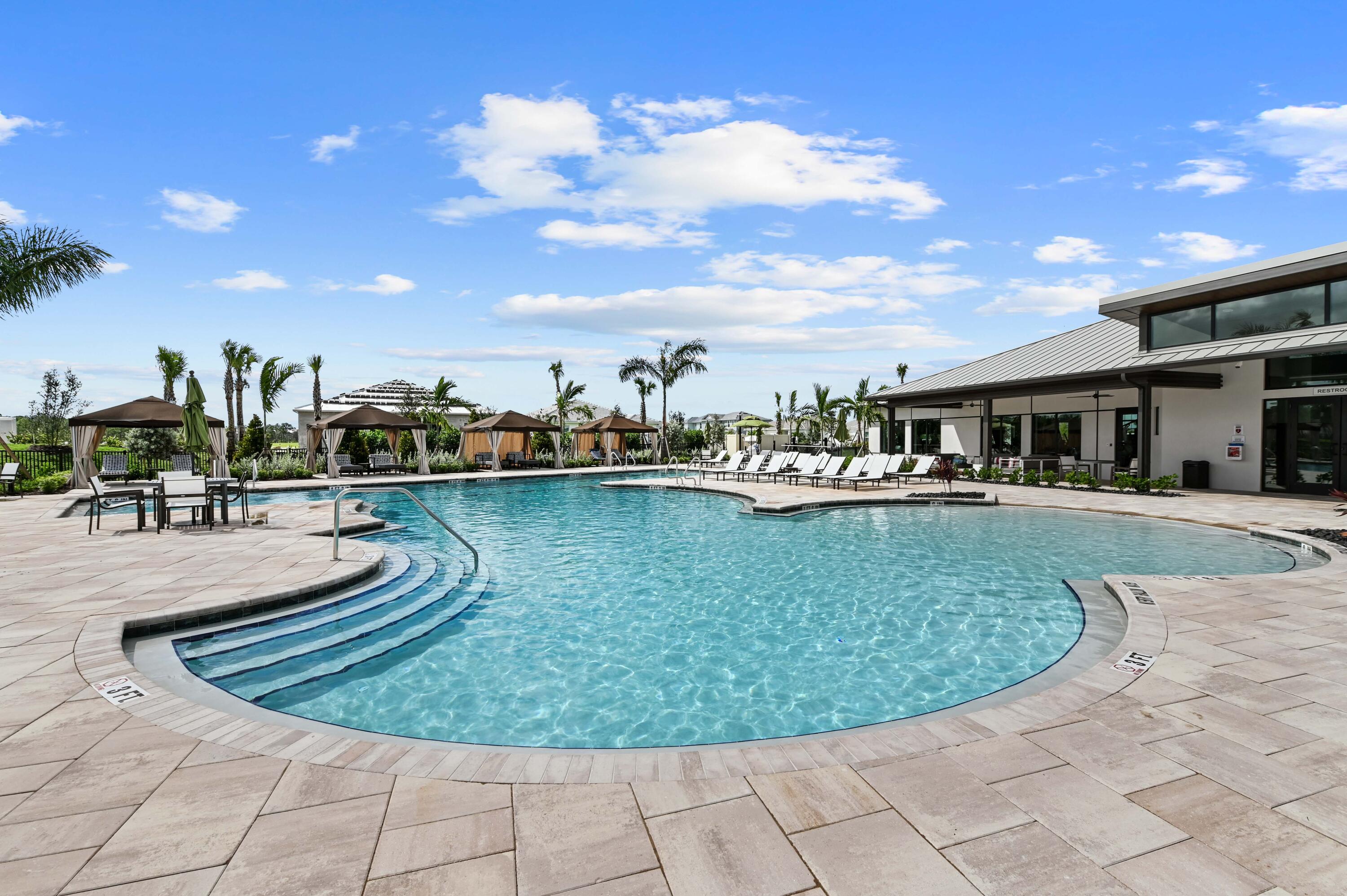 9891 Southwest Legacy Drive Stuart, FL 34997 - Photo 41 of 55 a view of a swimming pool with a table and chairs