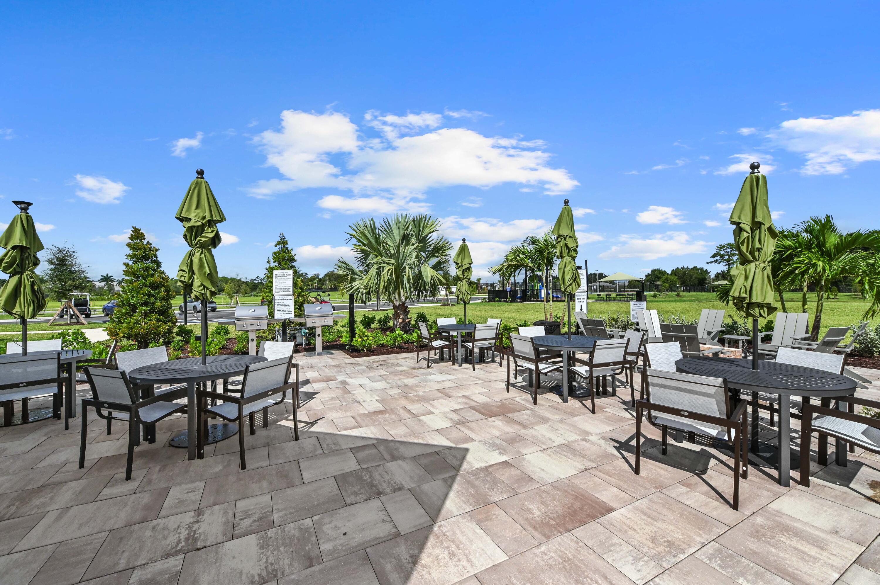 9891 Southwest Legacy Drive Stuart, FL 34997 - Photo 43 of 55 a view of a patio with a table and chairs and potted plants
