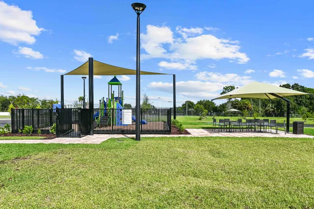 an aerial view of a house with a lake and a garden