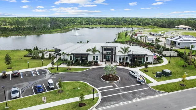 a view of a lake with a building and a big yard with plants