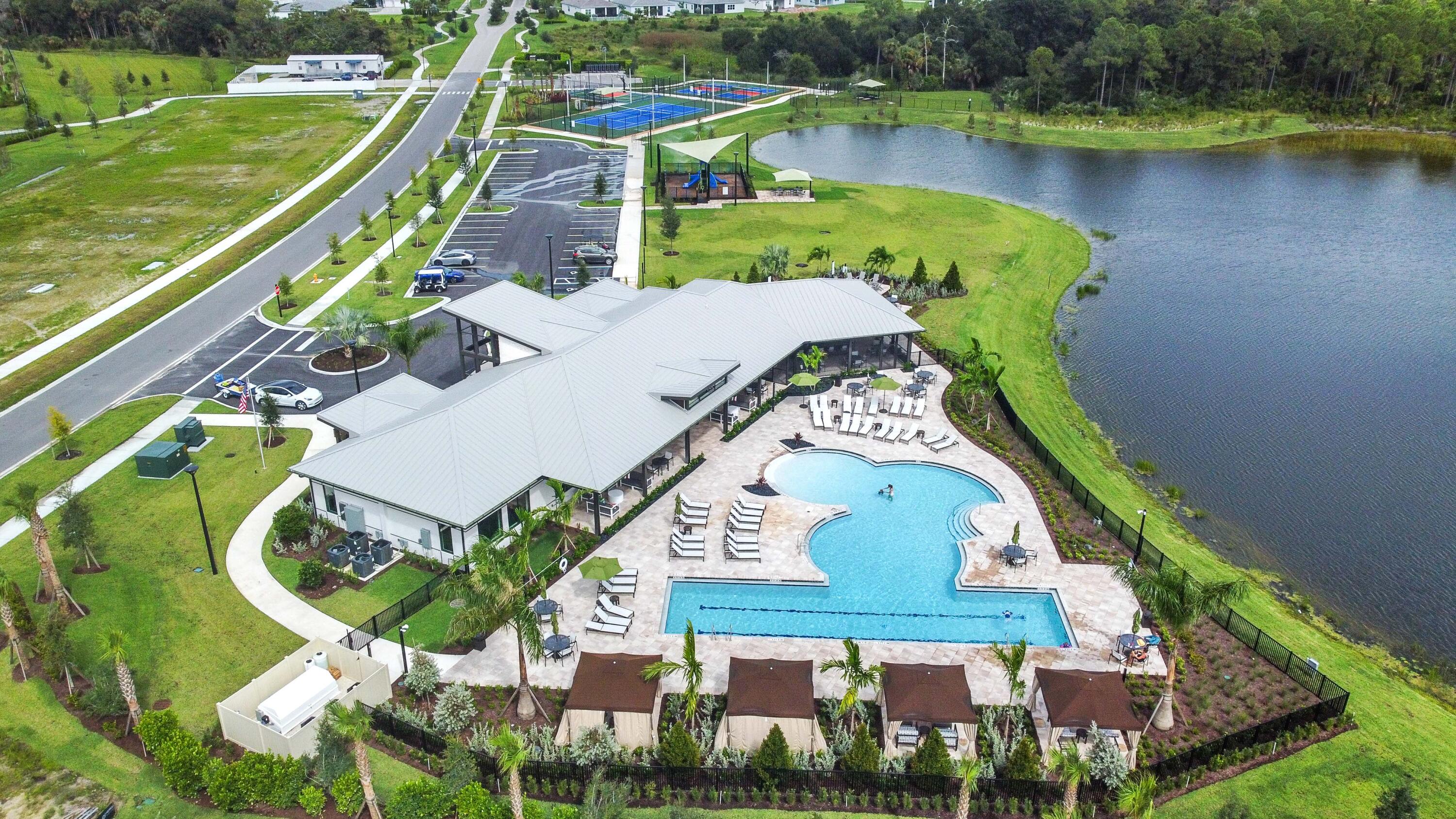 9891 Southwest Legacy Drive Stuart, FL 34997 - Photo 49 of 55 an aerial view of a house with a lake and a garden