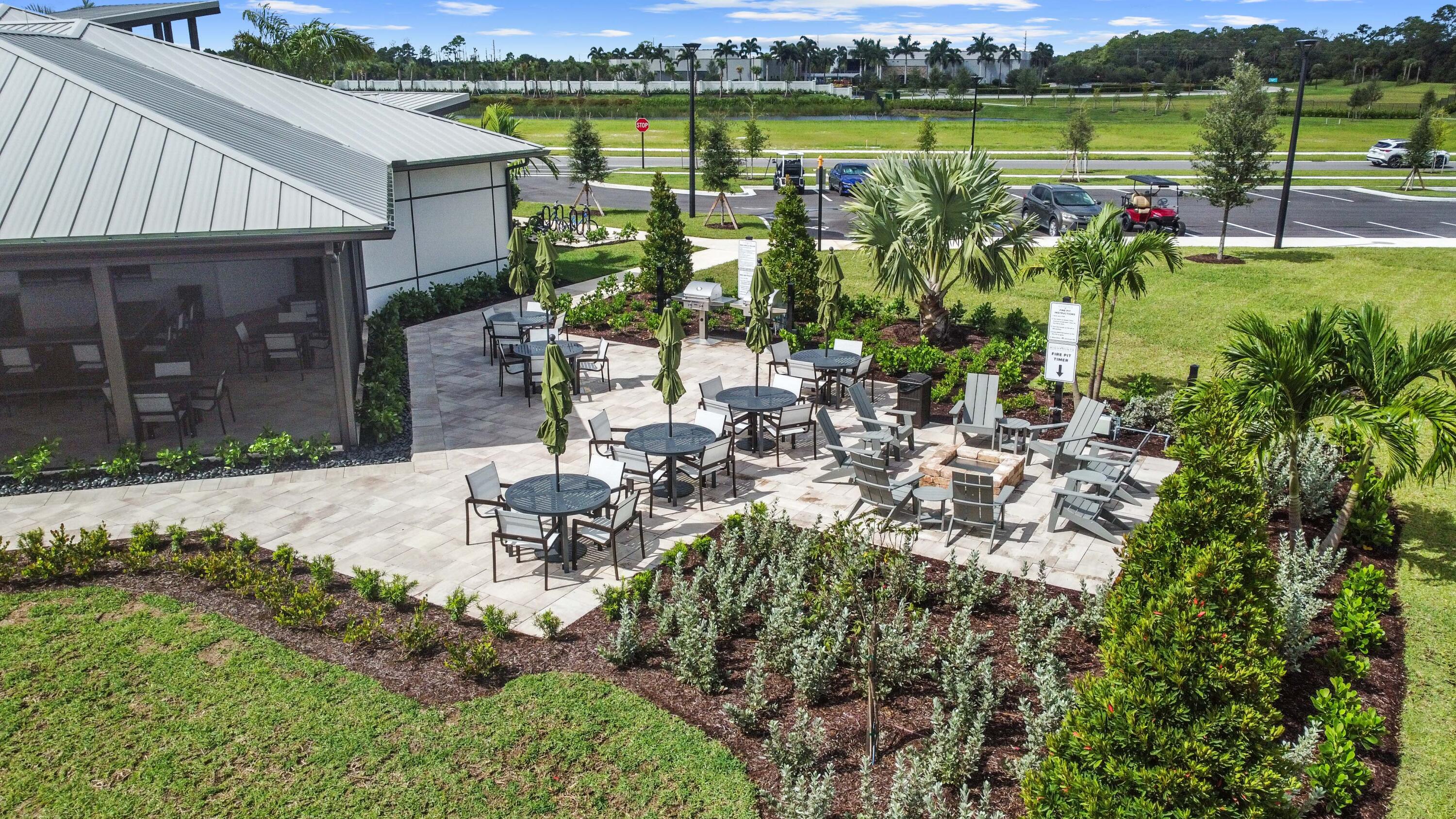 9891 Southwest Legacy Drive Stuart, FL 34997 - Photo 52 of 55 a view of a lake with a building and a big yard with plants