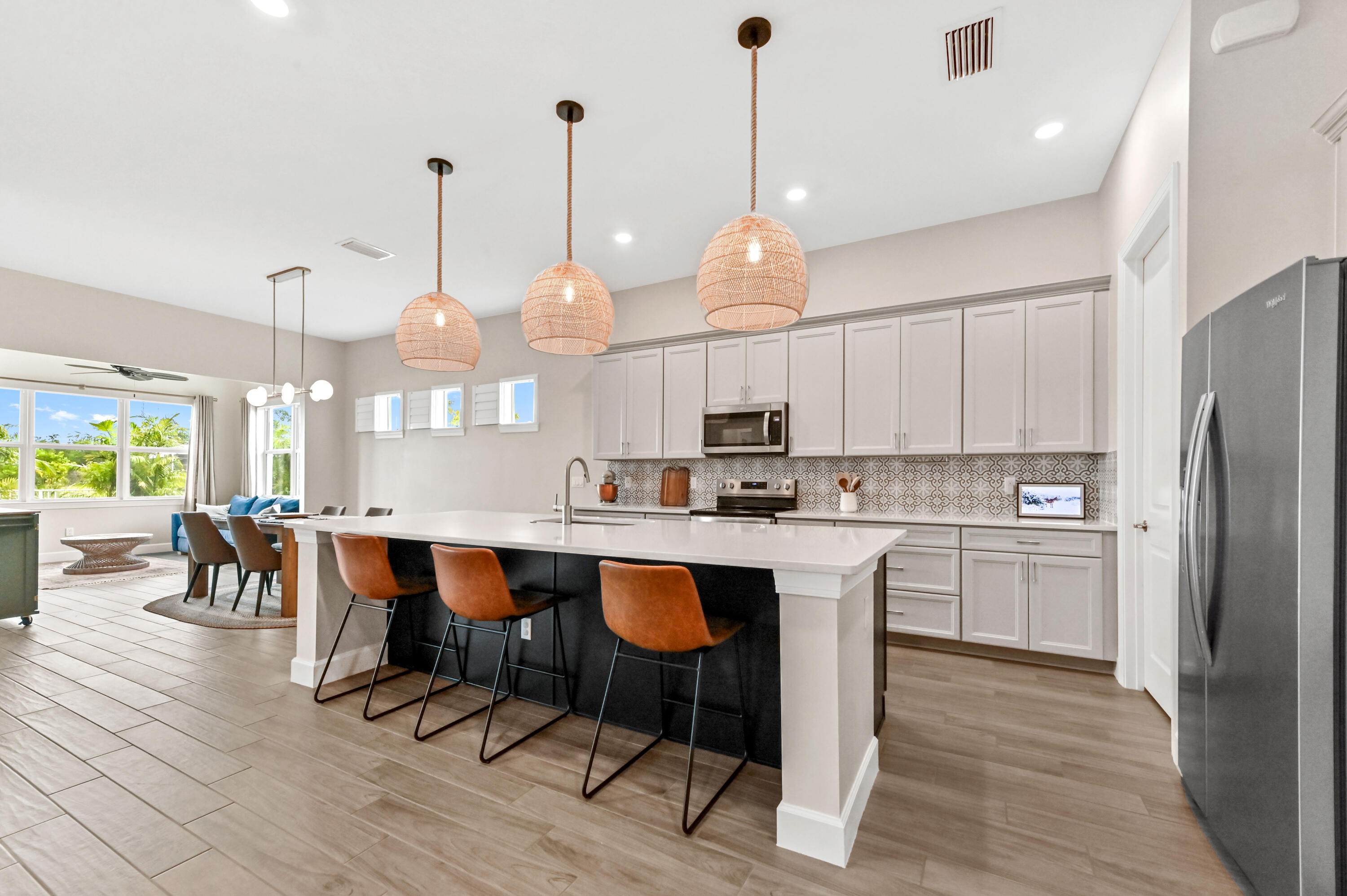 9891 Southwest Legacy Drive Stuart, FL 34997 - Photo 8 of 55 a kitchen with stainless steel appliances kitchen island a table and chairs in it