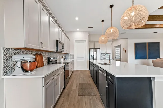 a large kitchen with stainless steel appliances kitchen island dining table and chairs