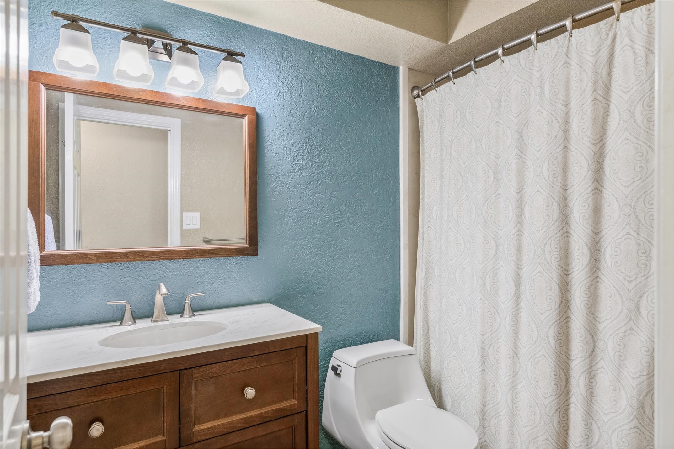 302 Erwin Street Edgewood, TX 75117 - Photo 25 of 40 a bathroom with a granite countertop sink vanity mirror and toilet