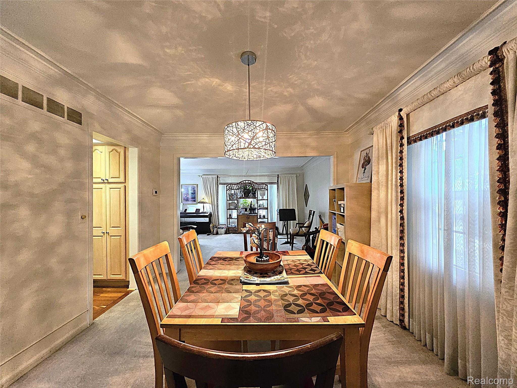 1114 Chaffer Drive Rochester, MI 48306 - Photo 27 of 50 Dining area featuring a contemporary chandelier, crown molding, and a built-in storage cabinet