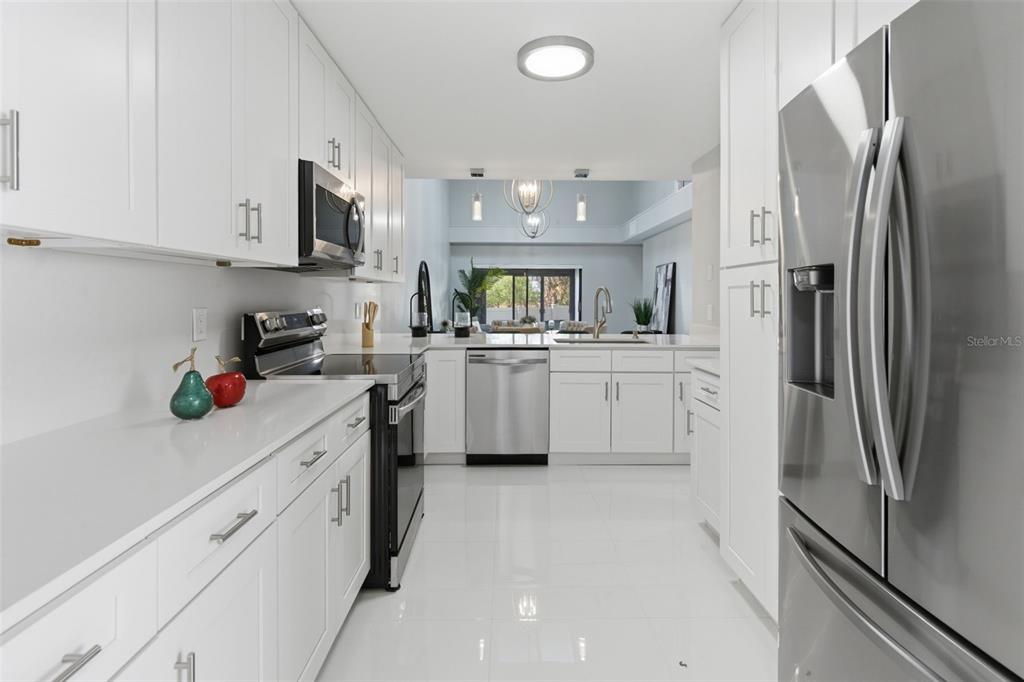 8044 Sandpoint Boulevard Orlando, FL 32819 - Photo 11 of 34 a kitchen with white cabinets and stainless steel appliances