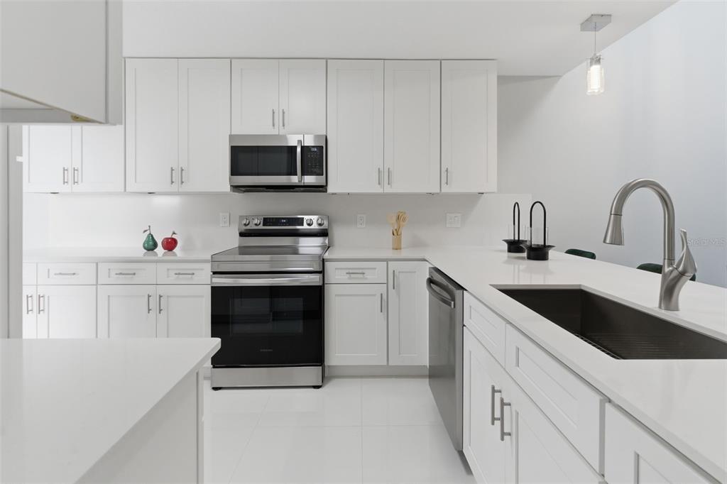 8044 Sandpoint Boulevard Orlando, FL 32819 - Photo 12 of 34 a kitchen with granite countertop white cabinets and stainless steel appliances