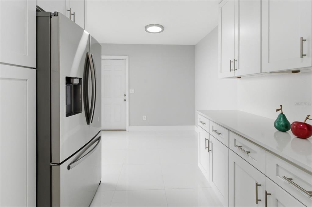 8044 Sandpoint Boulevard Orlando, FL 32819 - Photo 13 of 34 a view of a kitchen with white cabinets and refrigerator