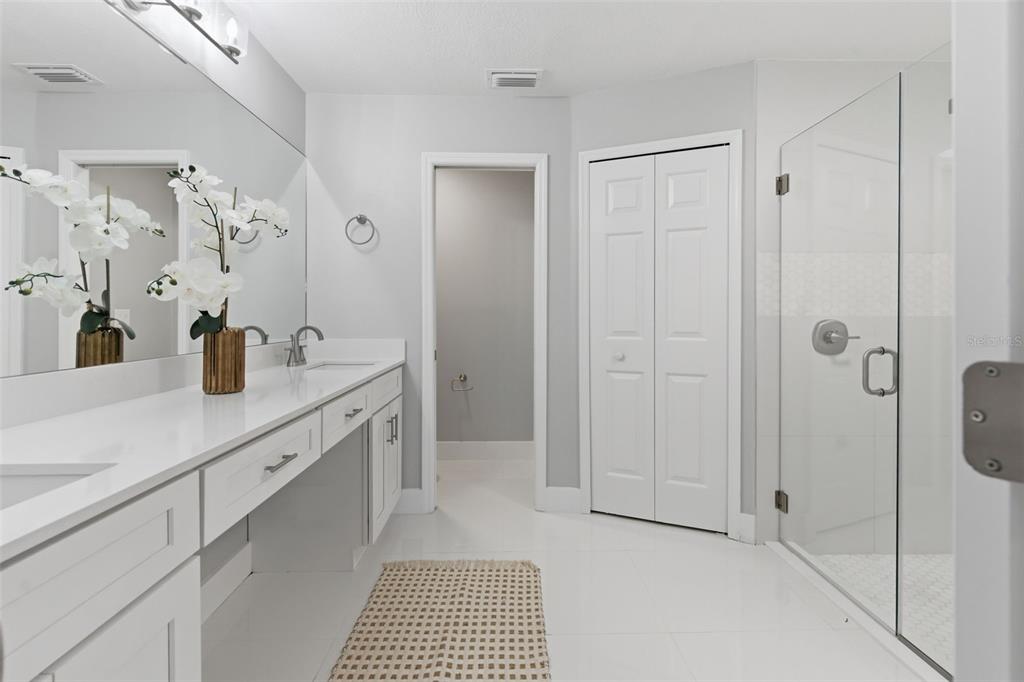 8044 Sandpoint Boulevard Orlando, FL 32819 - Photo 25 of 34 a spacious bathroom with a shower sink and mirror