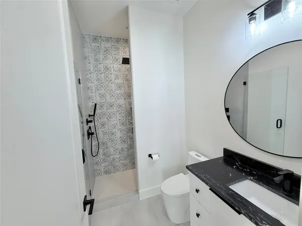 a bathroom with a granite countertop sink toilet and shower