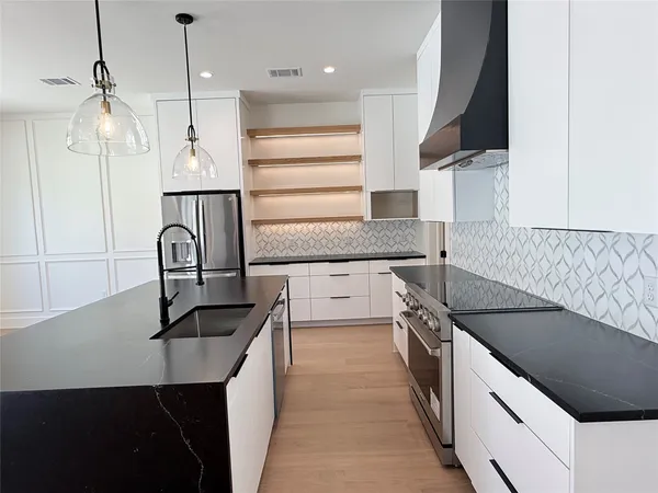 a kitchen with granite countertop a sink stainless steel appliances and cabinets