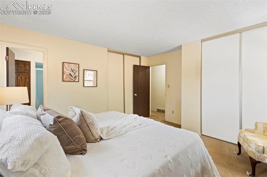 2113 Roundtop Court Colorado Springs, CO 80918 - Photo 18 of 34 a bedroom with a large bed and a closet