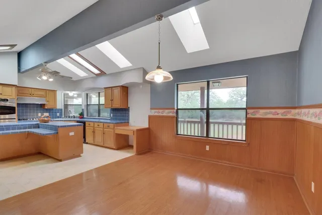a kitchen with kitchen island a large counter top space a sink stainless steel appliances and cabinets