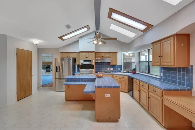 a living room with a black white checkered floor with a gaming machine and dining table