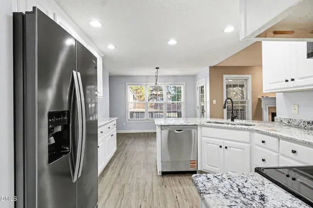 a view of a kitchen with wooden floor and windows