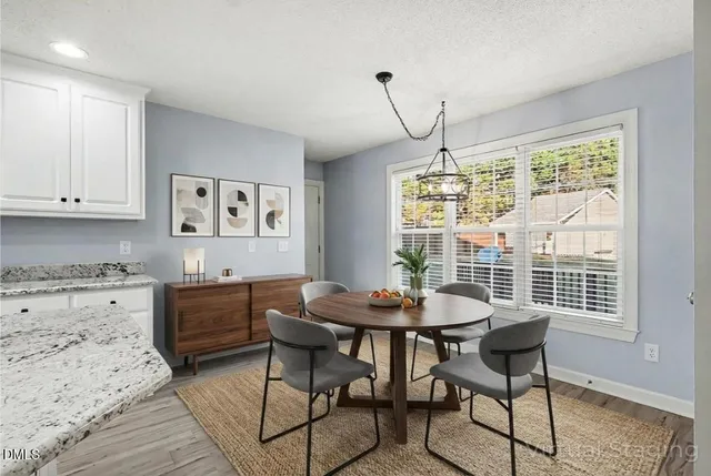 an empty room with wooden floor chandelier fan and windows