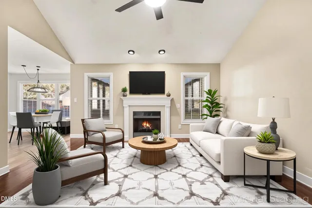a view of an empty room with wooden floor fireplace and a window