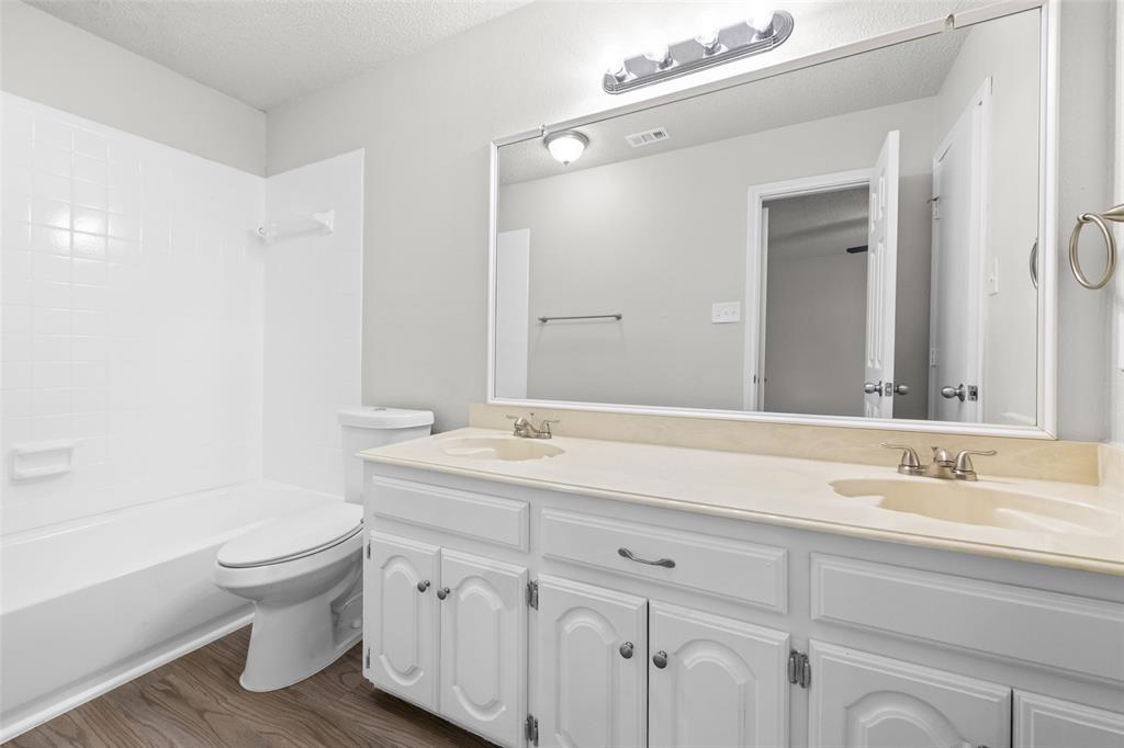 7501 Kings Ridge Road Frisco, TX 75035 - Photo 16 of 27 a bathroom with a granite countertop sink a toilet and a bathtub