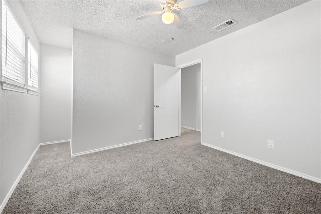 7501 Kings Ridge Road Frisco, TX 75035 - Photo 17 of 27 an empty room with a chandelier fan and windows
