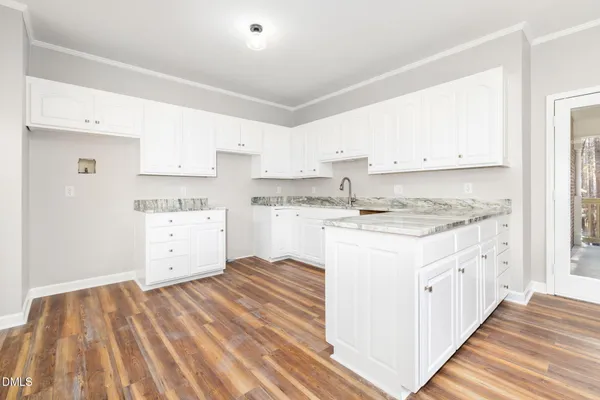 a view of empty room with wooden floor and fireplace