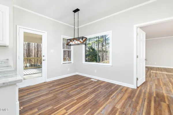 a kitchen with granite countertop white cabinets and wooden floor