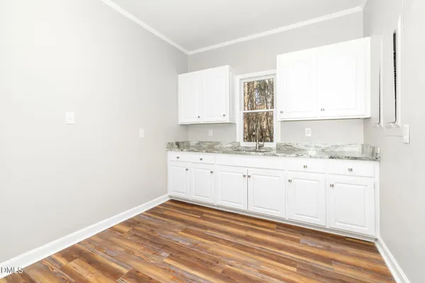a view of empty room with wooden floor and windows